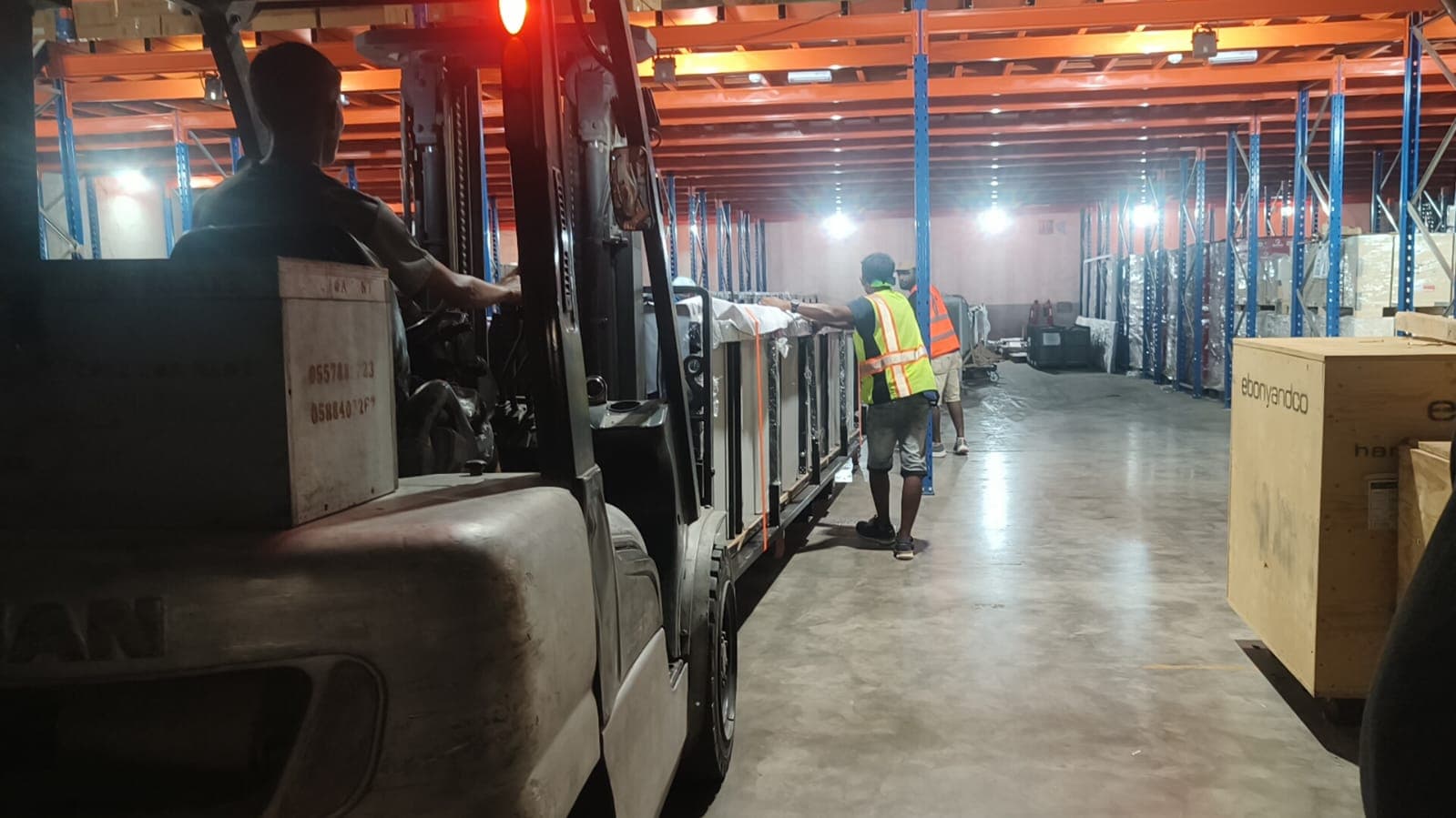 moveeasy staff moving crated goods through the warehouse by forklift