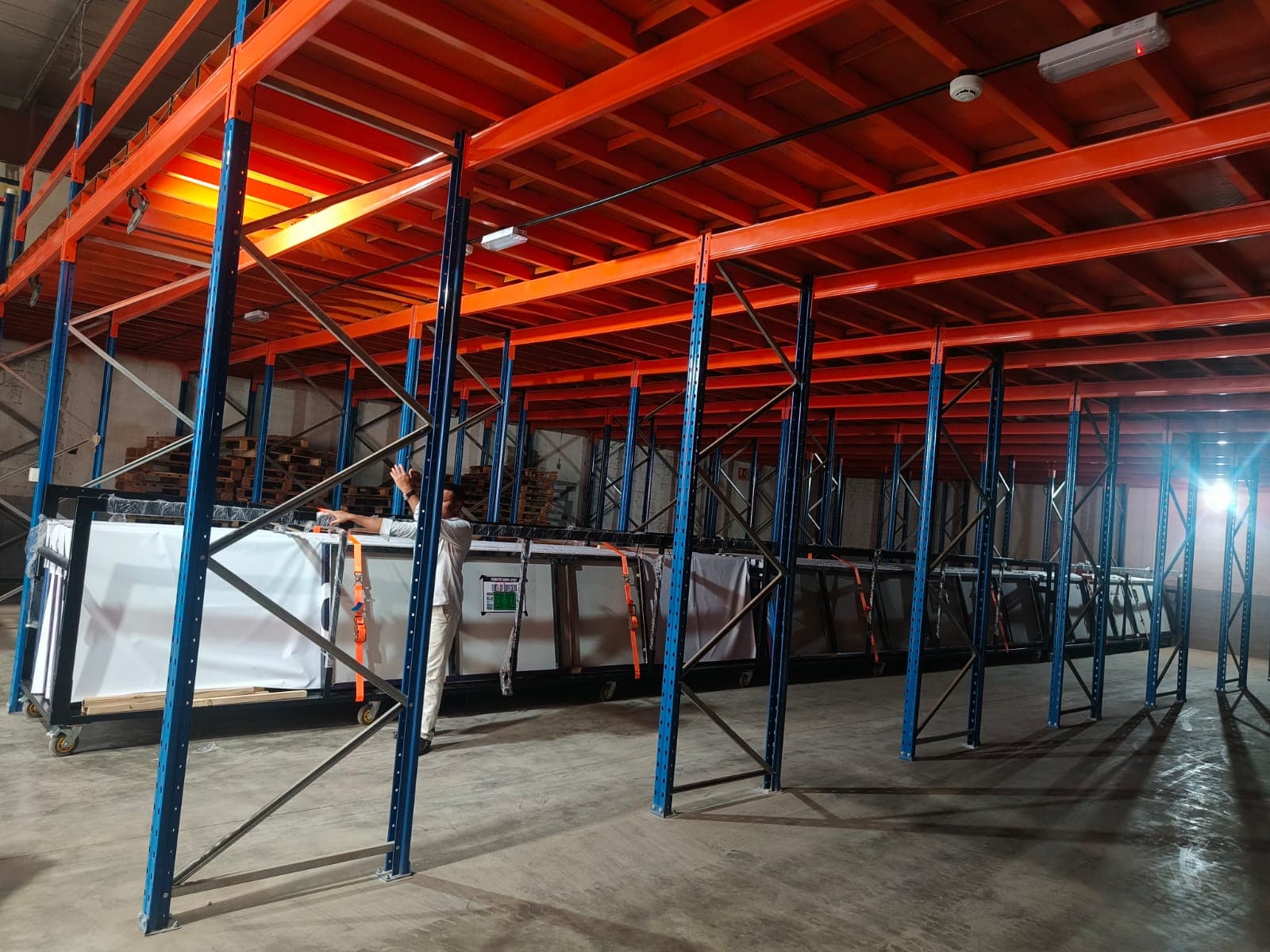 A moveeasy team member securing large crated panels on warehouse mezzanine racking